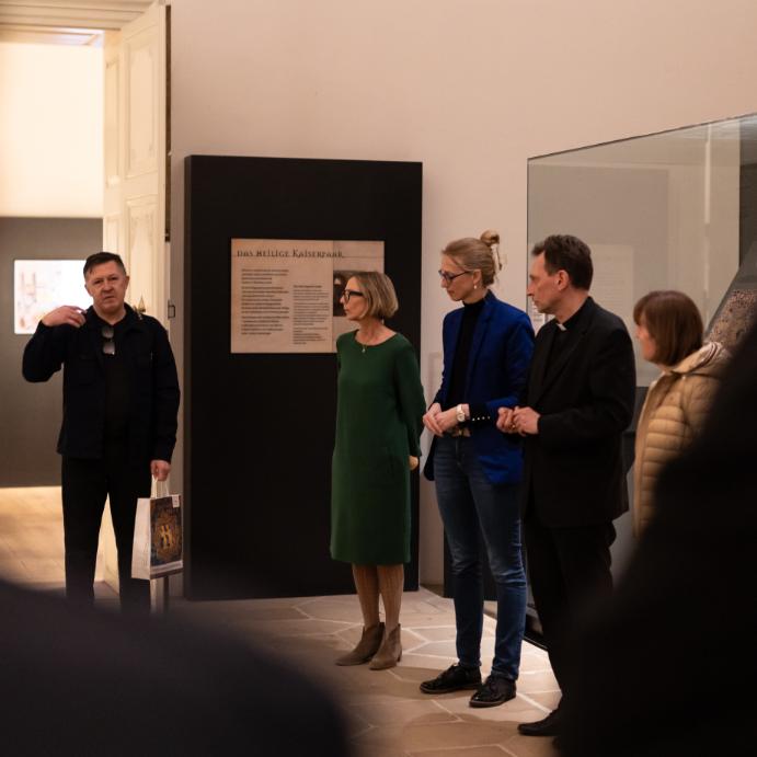 Das Bild zeigt u. a. Erzbischof Herwig Gössl, die Leiterin des Diözesanmuseums Carola Marie Schmidt und die Leiterin der Hauptabteilung Kunst und Kultur Birgit Kastner, die dem Künstler Gerelkhuu Ganbold zuhören.