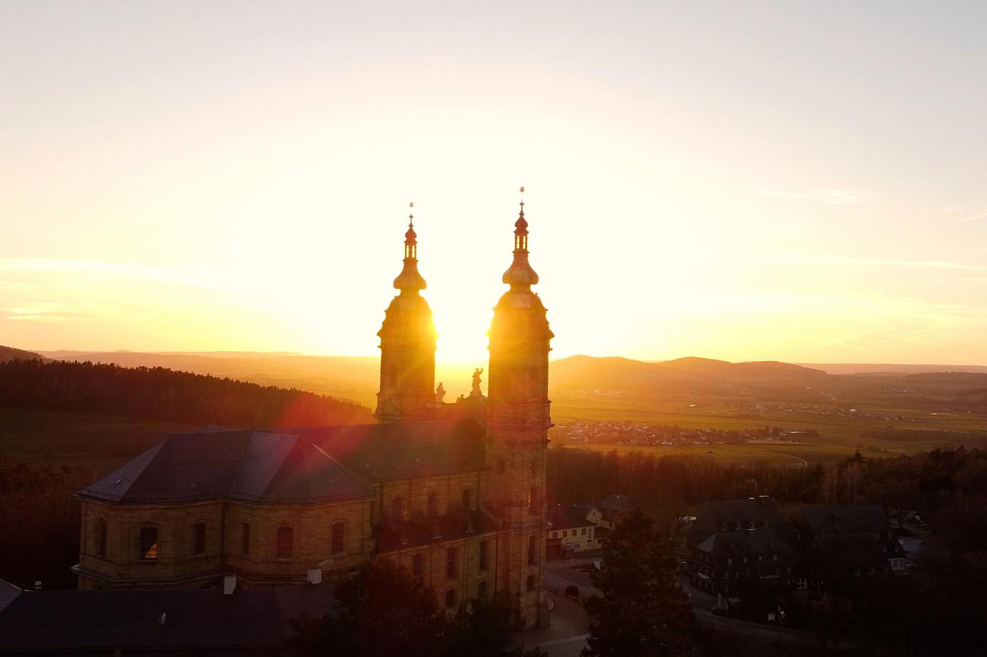 Das Bild zeigt die Basilika Vierzehnheiligen im Gegenlicht der Sonne.